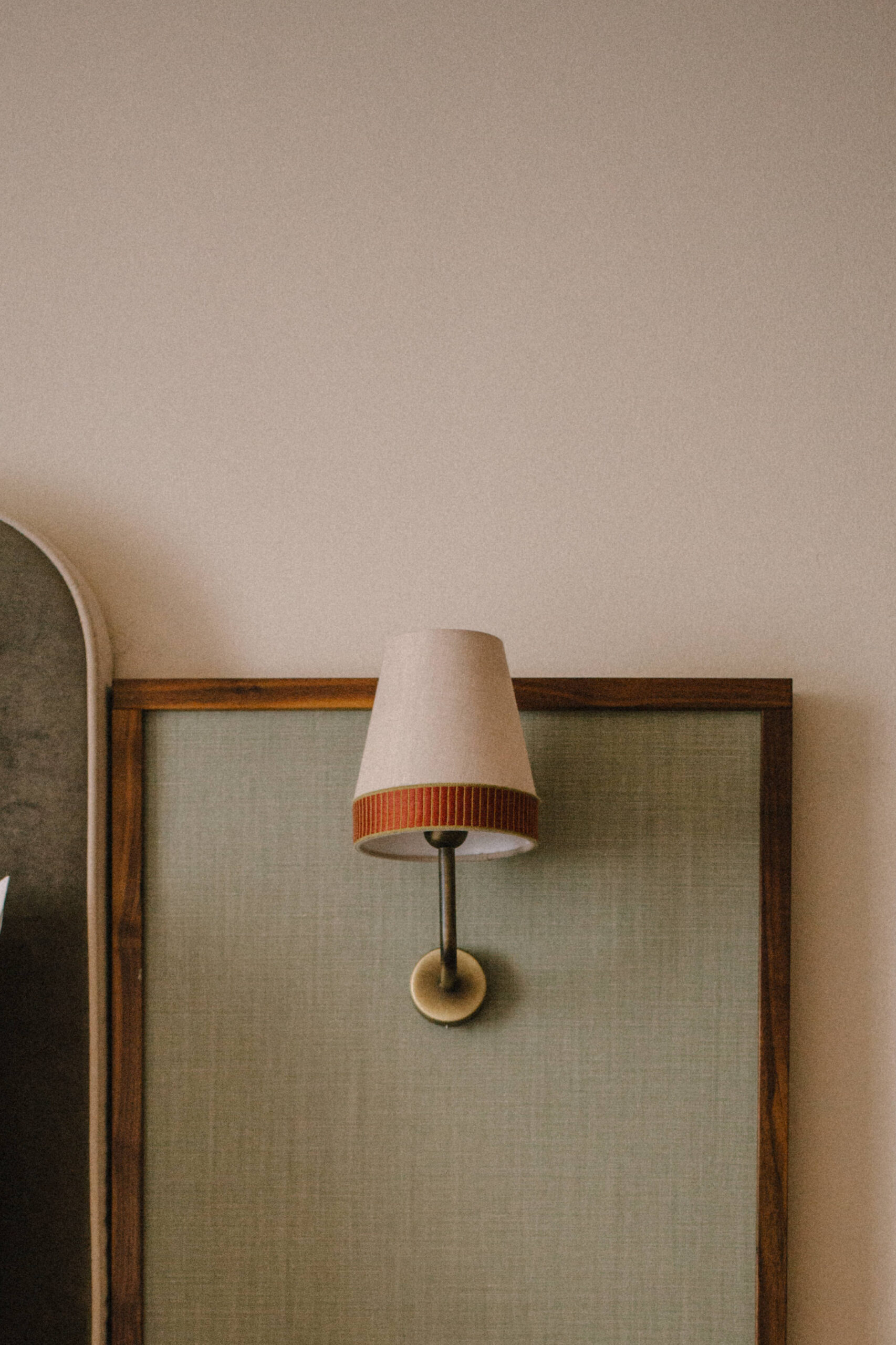 close up view of a cream colored sconce with brown trim