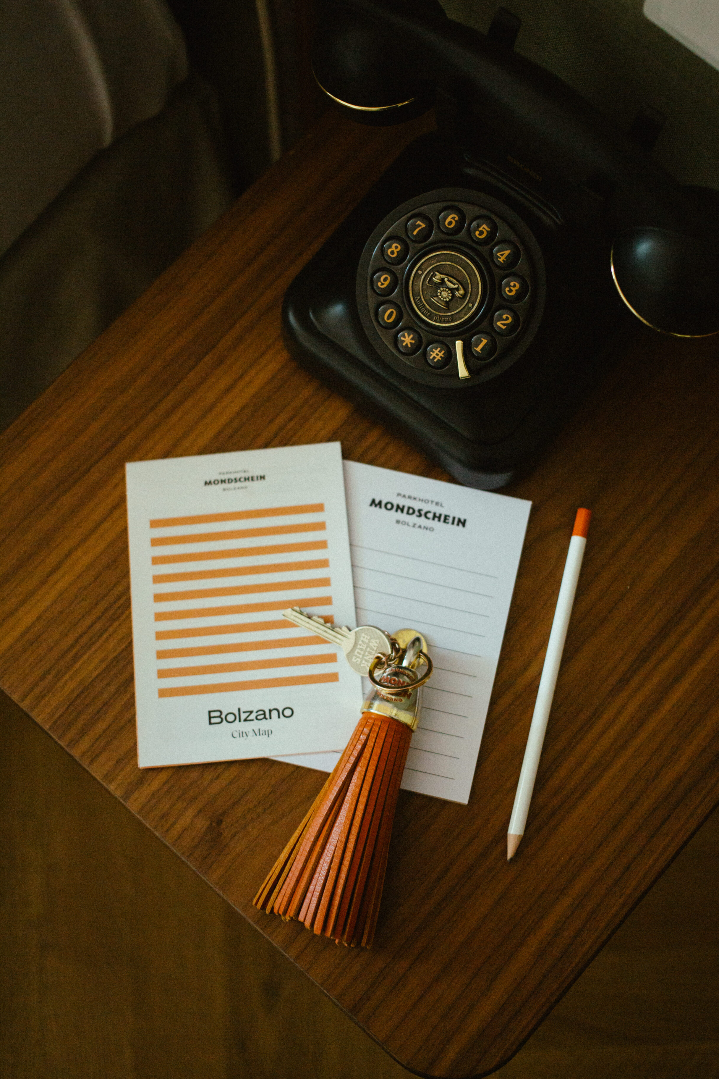 details of a hotel room including a cintage telephone pencil room key and pad of paper from parkhotel mondschein bolzano italy