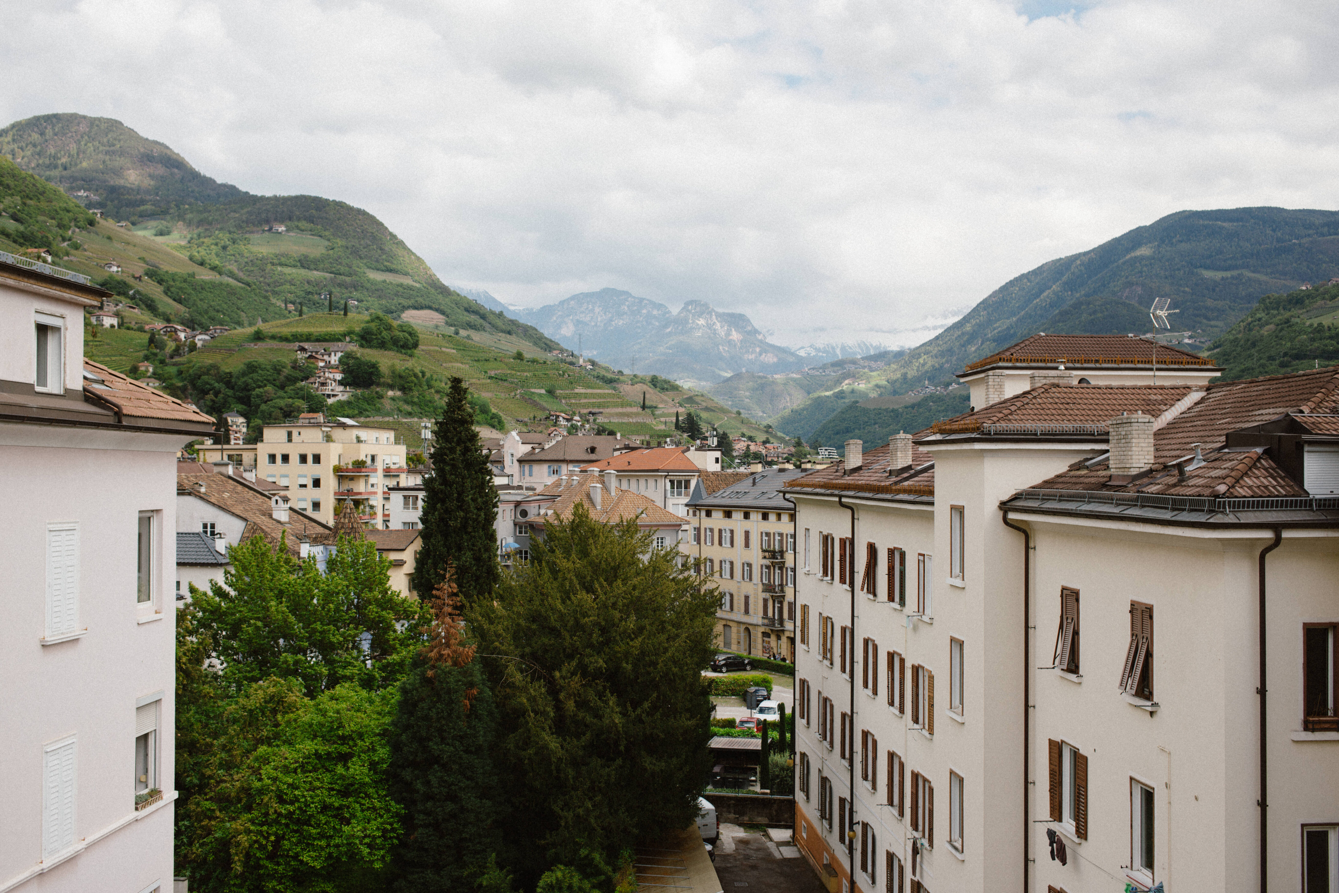 view from a balcony of the city of bolzano surrounded by vineyards and mountains