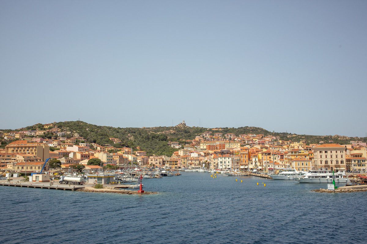 a closer view of the port of la maddalena from the strait showing red rooftops and italian style architecture