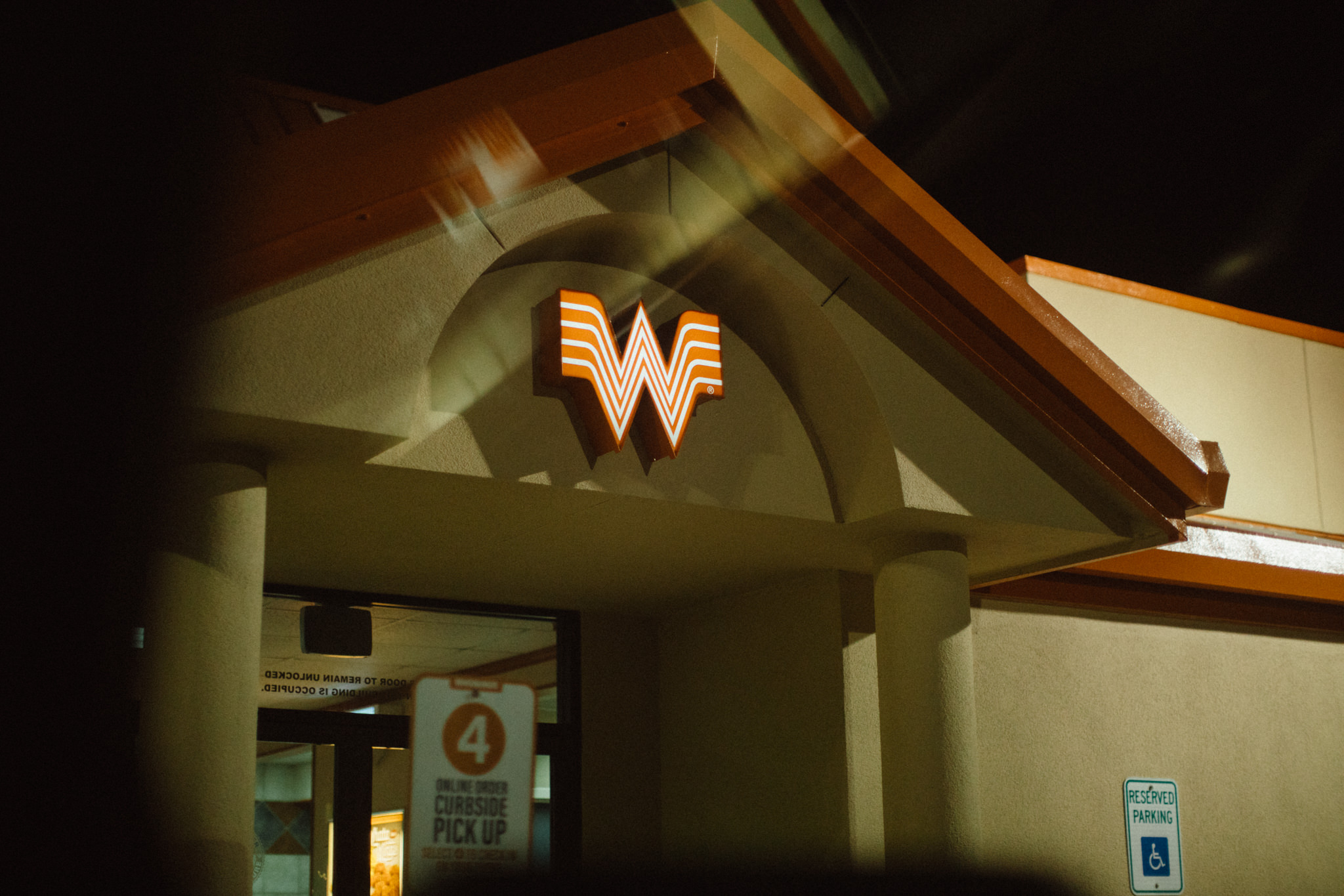 night time photograph of the outside of a whataburger curbside pick up area in san antonio texas